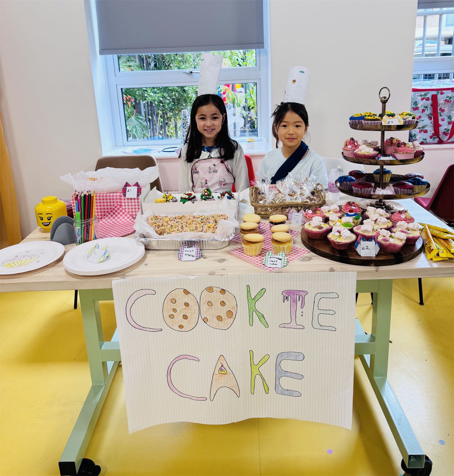 Two children selling cakes at their stall at the Young Founders Market