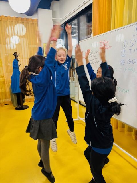 Children reaching up together at Rise to Lead